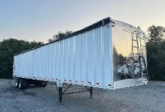 White commodity trailer with tall aluminum sidewalls and rear unloading doors
