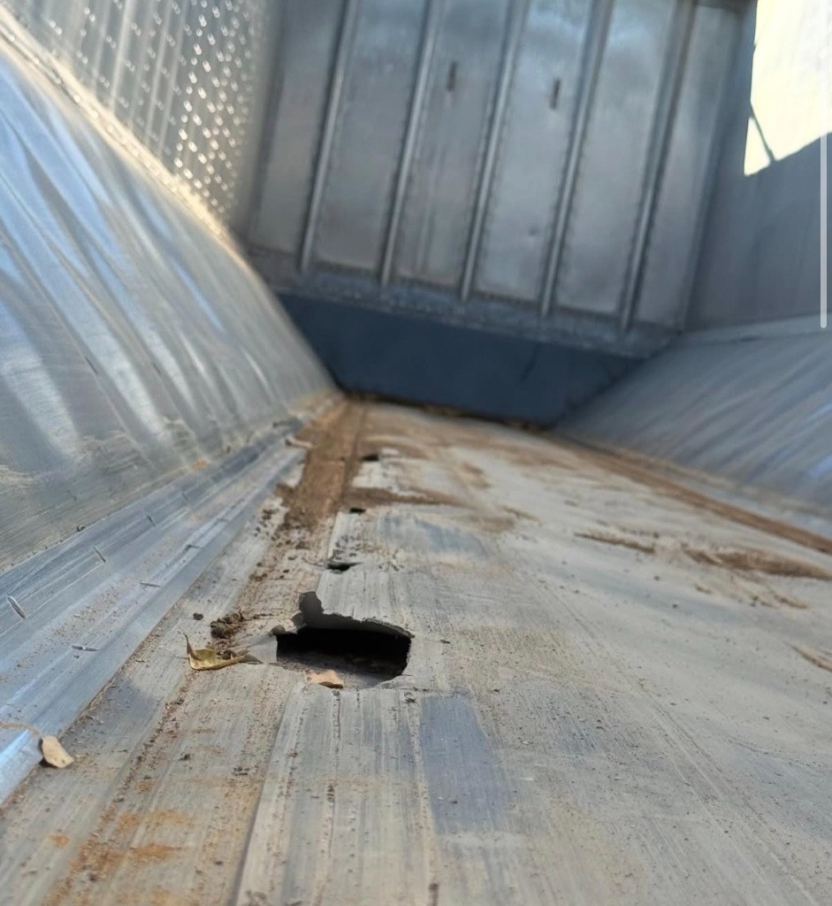 Worn trailer liner with visible holes and damaged material